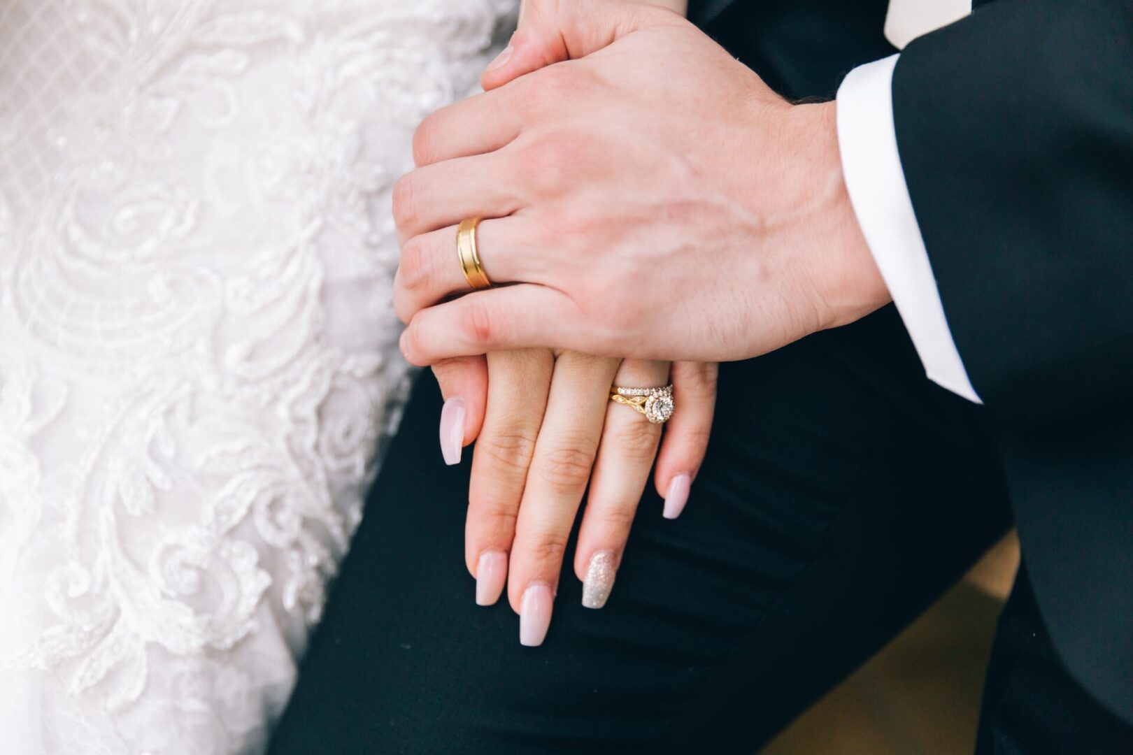 Two hands with wedding rings on top of each other.