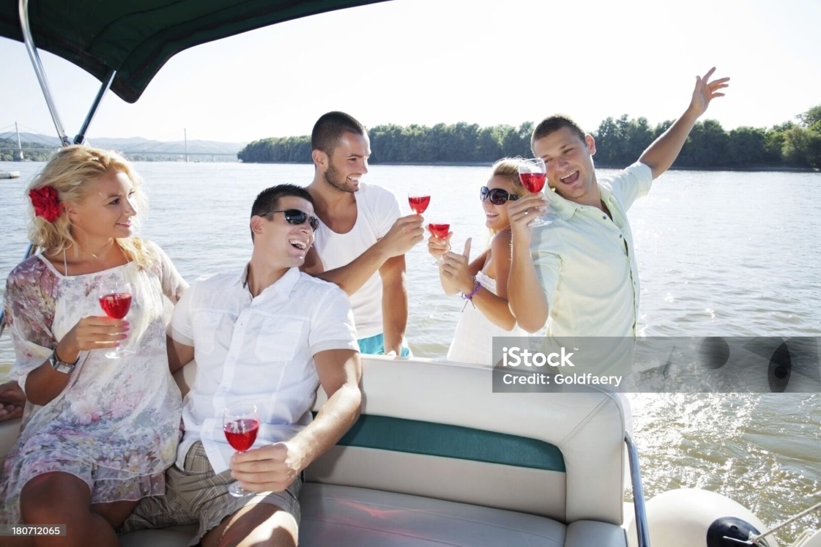 "Group of friends having fun on a yacht, drinking wine and laughing."